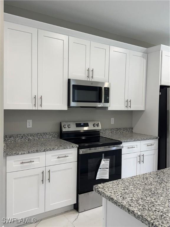 543 Mcarthur Blvd, Lehigh Acres, FL 33974 - kitchen with appliances with stainless steel finishes, white cabinets, and light stone counters