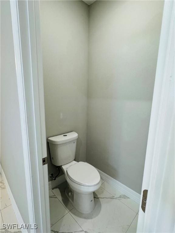 543 Mcarthur Blvd, Lehigh Acres, FL 33974 - bathroom with toilet, marble finish floors, and baseboards