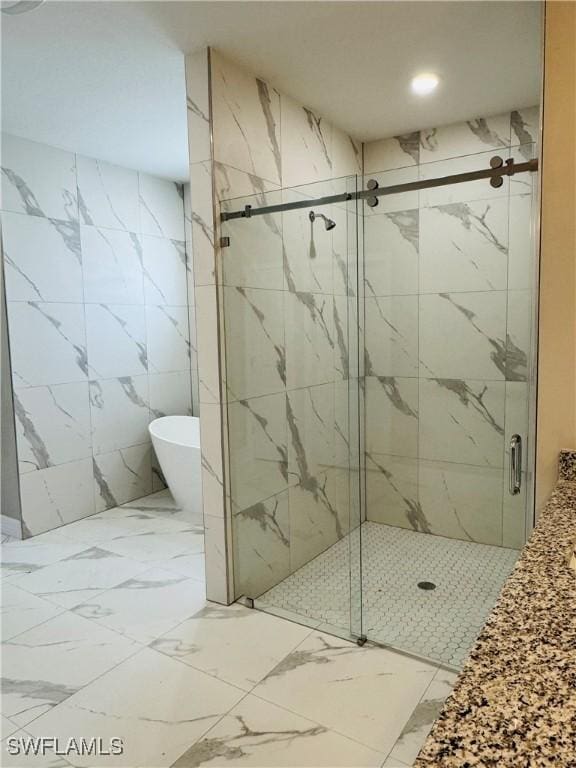 543 Mcarthur Blvd, Lehigh Acres, FL 33974 - full bath featuring marble look tile flooring, a soaking tub, a marble finish shower, and recessed lighting