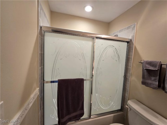 bathroom featuring toilet and enclosed tub / shower combo