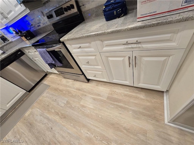 kitchen with light wood-style flooring, dishwasher, white cabinets, and light stone countertops