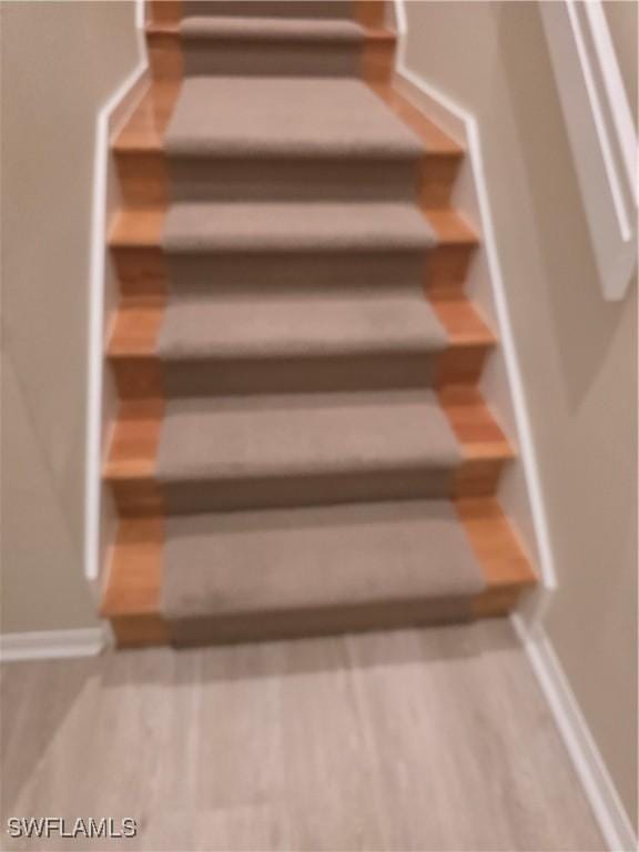 stairs featuring wood finished floors and baseboards