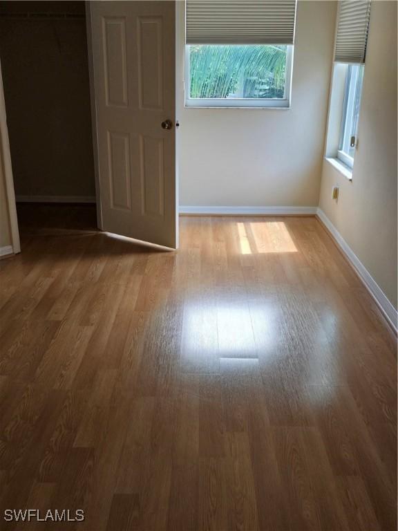 spare room featuring wood finished floors and baseboards