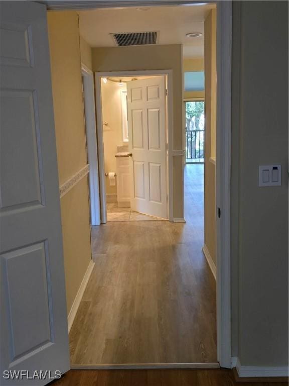 hall featuring wood finished floors and baseboards