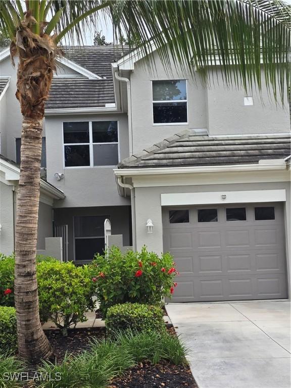 12051 Champions Green Way Unit 322, Fort Myers, FL 33913 - view of front of house featuring stucco siding, an attached garage, and concrete driveway