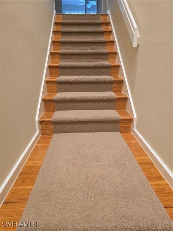 12051 Champions Green Way Unit 322, Fort Myers, FL 33913 - stairs featuring baseboards, wood finished floors, and a textured wall