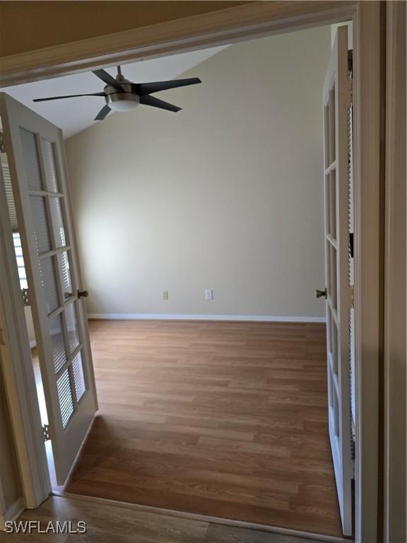 12051 Champions Green Way Unit 322, Fort Myers, FL 33913 - spare room with baseboards, wood finished floors, ceiling fan, and lofted ceiling