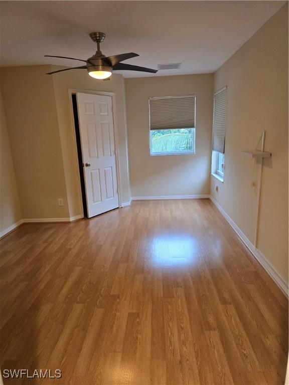 12051 Champions Green Way Unit 322, Fort Myers, FL 33913 - spare room with light wood-style flooring, ceiling fan, and baseboards