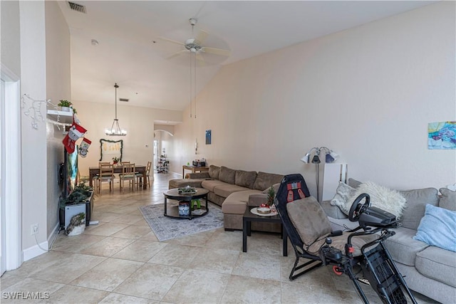 living room with light tile patterned floors, ceiling fan with notable chandelier, and vaulted ceiling