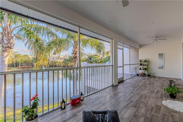 unfurnished sunroom featuring a water view and ceiling fan