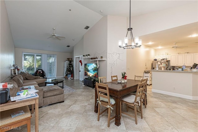 dining space featuring light tile patterned flooring, ceiling fan with notable chandelier, and high vaulted ceiling