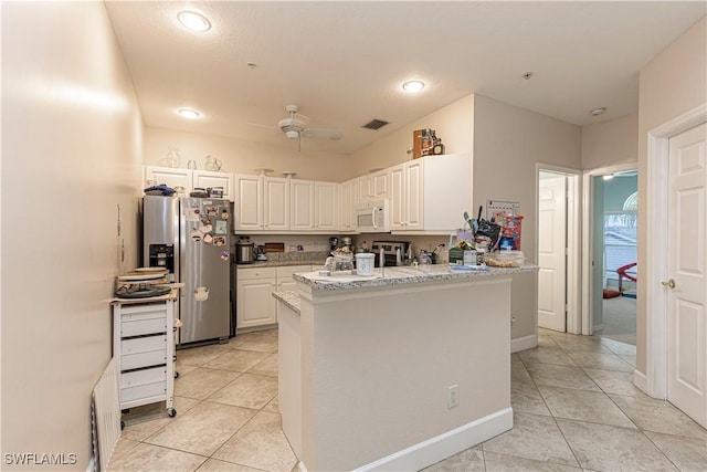 kitchen featuring stainless steel fridge, white cabinets, light tile patterned floors, ceiling fan, and kitchen peninsula