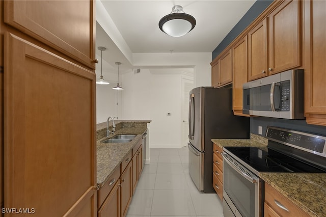 kitchen with sink, stainless steel appliances, hanging light fixtures, and stone countertops