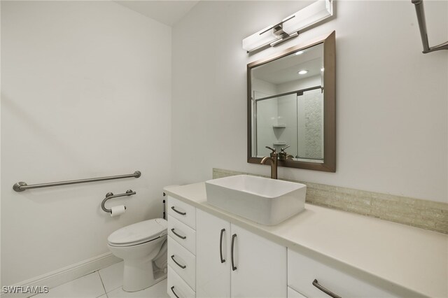 bathroom with toilet, tile patterned flooring, vanity, and walk in shower