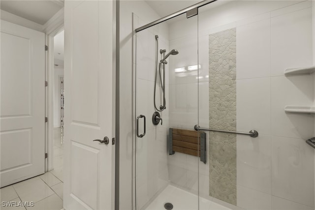 bathroom with an enclosed shower and tile patterned flooring