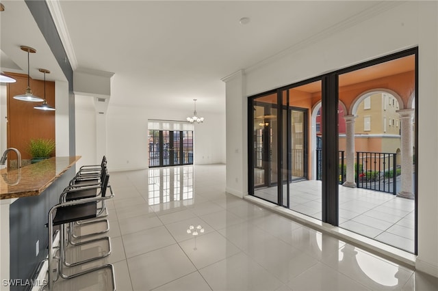 interior space with light tile patterned floors, a chandelier, and ornamental molding