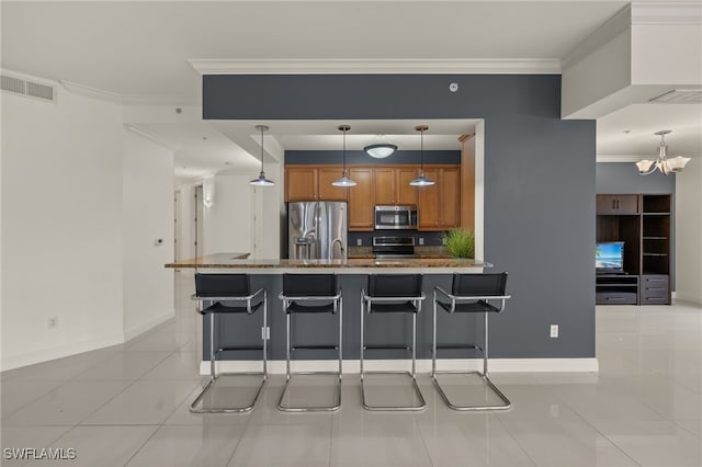 kitchen with appliances with stainless steel finishes, light tile patterned floors, a kitchen breakfast bar, decorative light fixtures, and ornamental molding