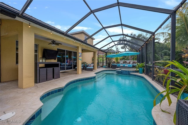 view of swimming pool with an in ground hot tub, ceiling fan, a patio, and glass enclosure