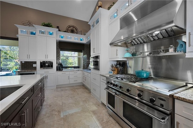 kitchen featuring white cabinetry, extractor fan, tasteful backsplash, and appliances with stainless steel finishes