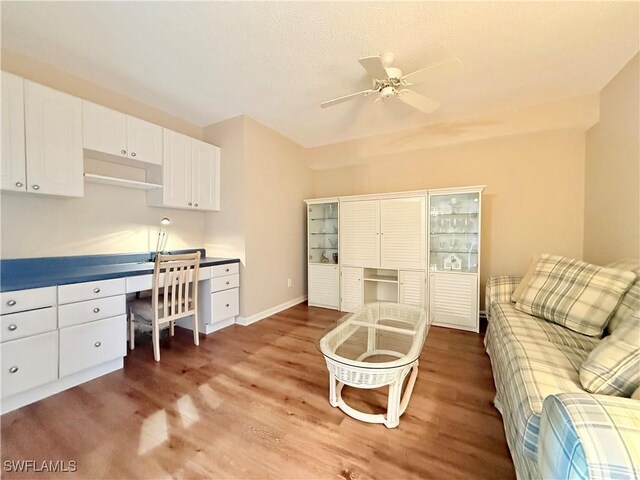 interior space featuring ceiling fan, dark hardwood / wood-style floors, and built in desk