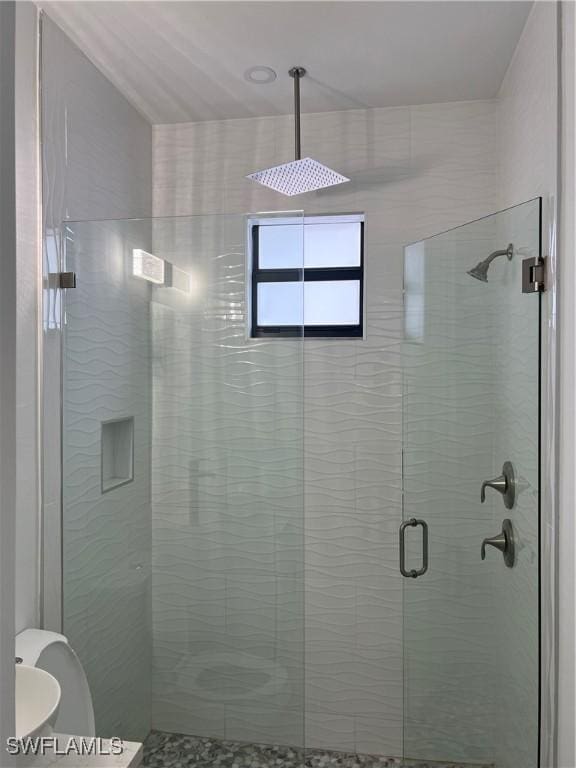 bathroom with a shower with door