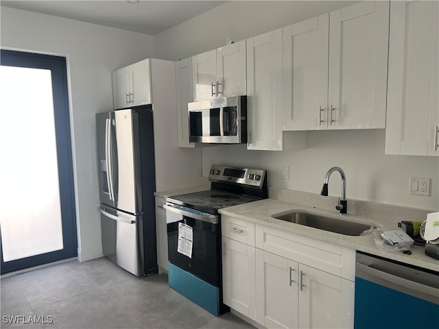 kitchen with white cabinets, appliances with stainless steel finishes, and sink