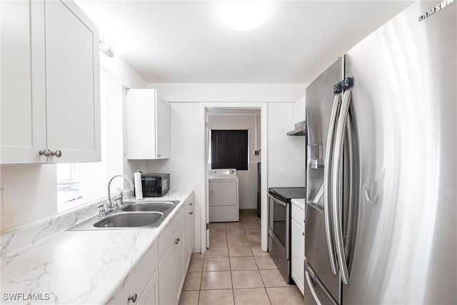 kitchen featuring sink, appliances with stainless steel finishes, white cabinets, light tile patterned flooring, and washer / dryer