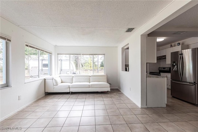 unfurnished living room with a textured ceiling and light tile patterned flooring