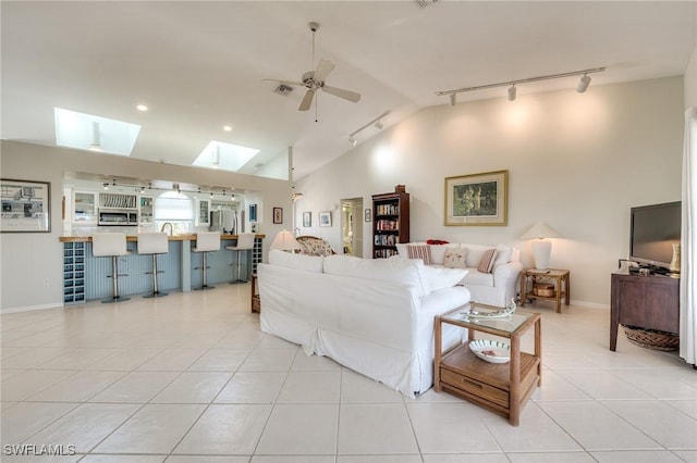 3025 Turtle Gait Ln, Sanibel, FL 33957 - living area featuring light tile patterned floors, visible vents, a ceiling fan, lofted ceiling with skylight, and rail lighting