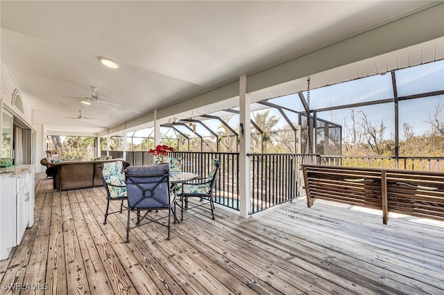 3025 Turtle Gait Ln, Sanibel, FL 33957 - wooden deck featuring outdoor dining area, glass enclosure, and a ceiling fan
