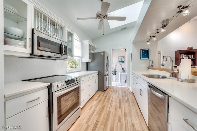 3025 Turtle Gait Ln, Sanibel, FL 33957 - kitchen with light wood-style flooring, a ceiling fan, white cabinets, appliances with stainless steel finishes, and a sink