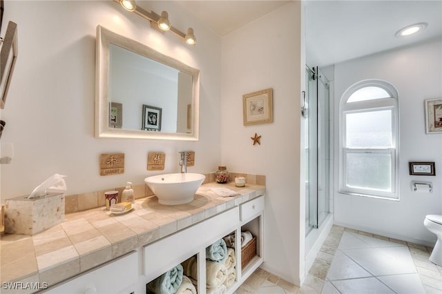 3025 Turtle Gait Ln, Sanibel, FL 33957 - full bath featuring vanity, a shower with door, toilet, tile patterned floors, and baseboards
