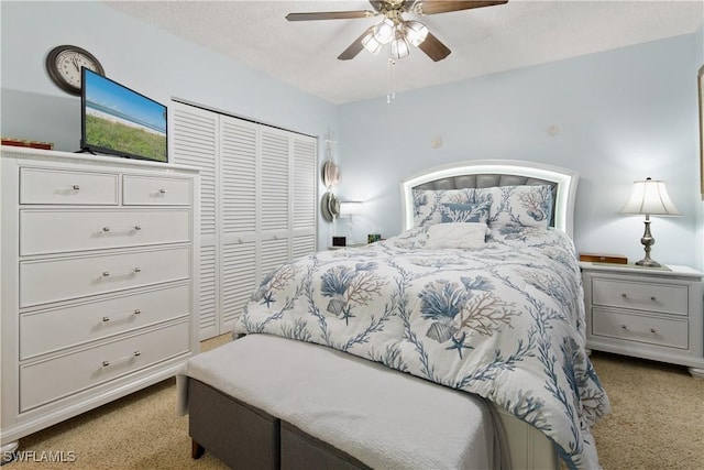 carpeted bedroom with ceiling fan, a textured ceiling, and a closet