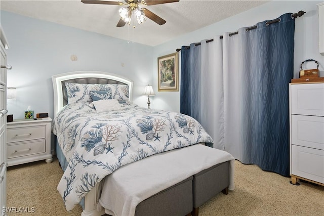 bedroom featuring ceiling fan, light colored carpet, and a textured ceiling