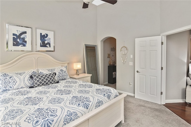 carpeted bedroom featuring a high ceiling and ceiling fan