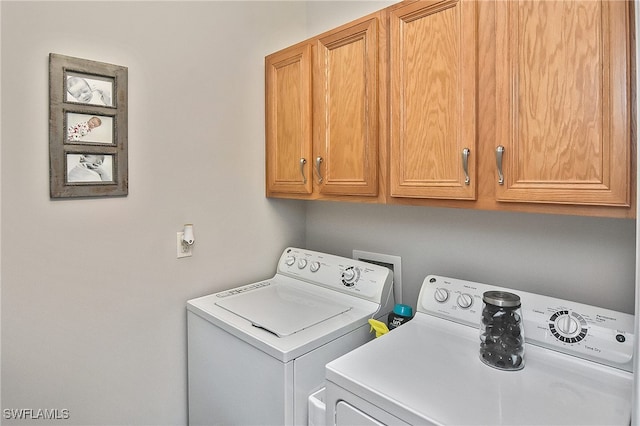 laundry room featuring cabinets and washer and dryer