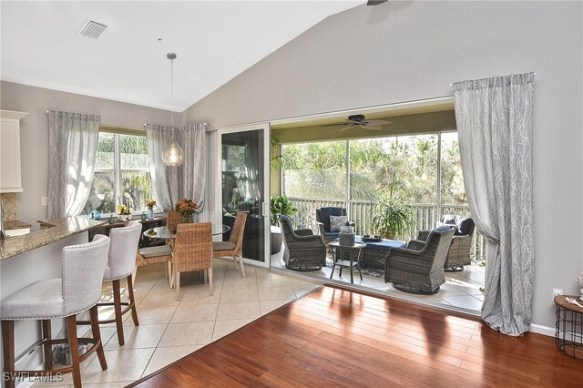 dining area with lofted ceiling, light tile patterned floors, and ceiling fan