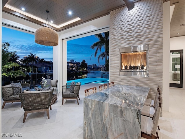 patio terrace at dusk with an outdoor living space with a fireplace