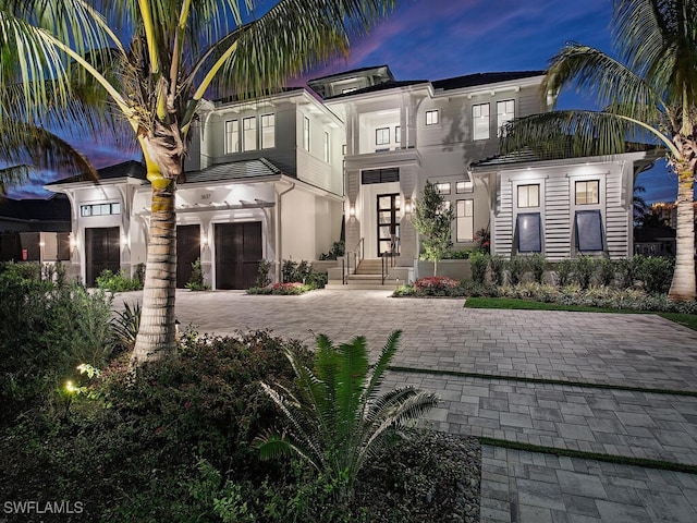 3637 Crayton Rd, Naples, FL 34103 - view of front facade with stucco siding, decorative driveway, and an attached garage