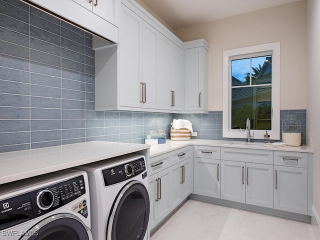 washroom featuring cabinets, sink, and independent washer and dryer