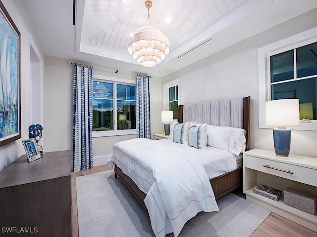 bedroom featuring an inviting chandelier and light hardwood / wood-style flooring