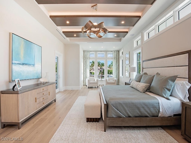 bedroom featuring a notable chandelier, beam ceiling, and light hardwood / wood-style floors