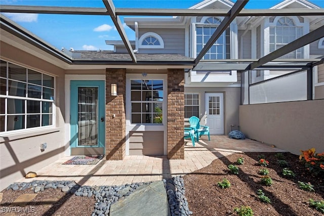 exterior space with brick siding and a patio