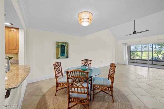 dining space with ceiling fan, light tile patterned flooring, baseboards, vaulted ceiling, and ornamental molding