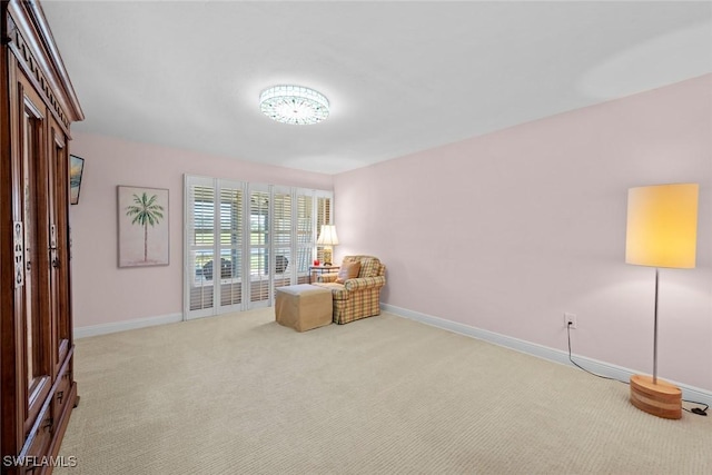 sitting room with baseboards and carpet flooring