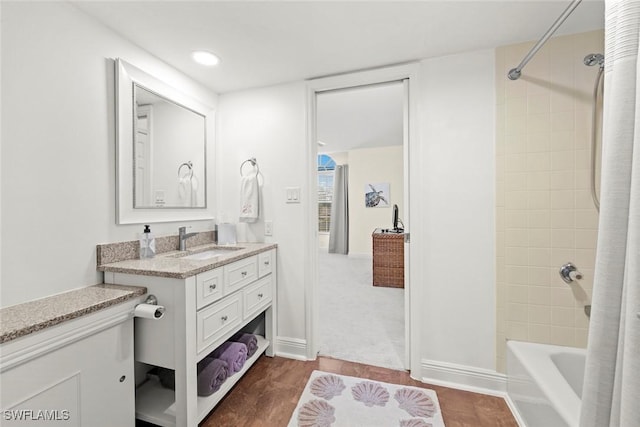 bathroom with shower / bathtub combination, vanity, and baseboards