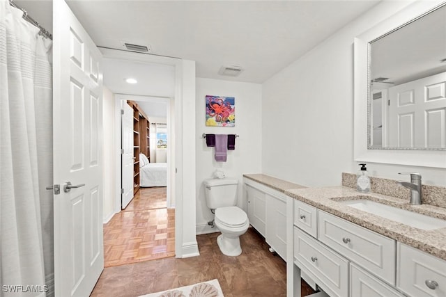 bathroom with baseboards, visible vents, vanity, and toilet