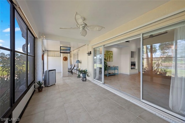 unfurnished sunroom with ceiling fan