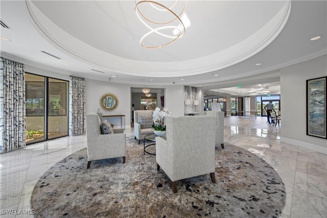 living area featuring baseboards, a tray ceiling, a notable chandelier, and ornamental molding