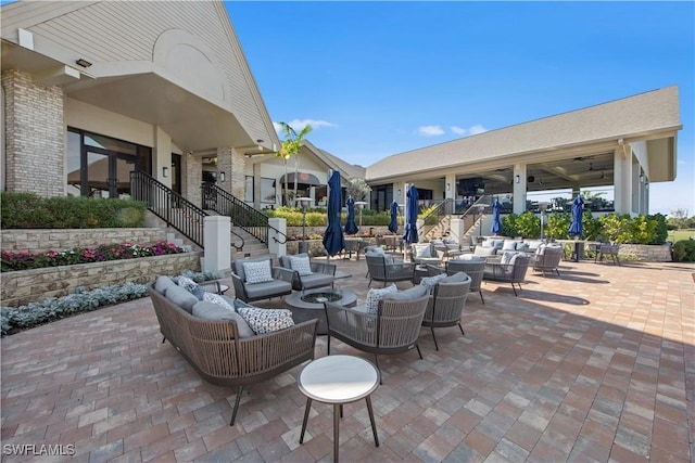 view of patio with an outdoor living space with a fire pit